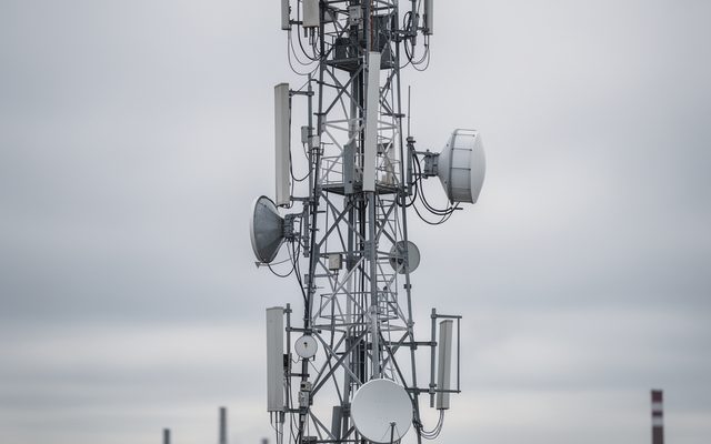 Industrial antennas mounted on a steel tower against an overcast sky